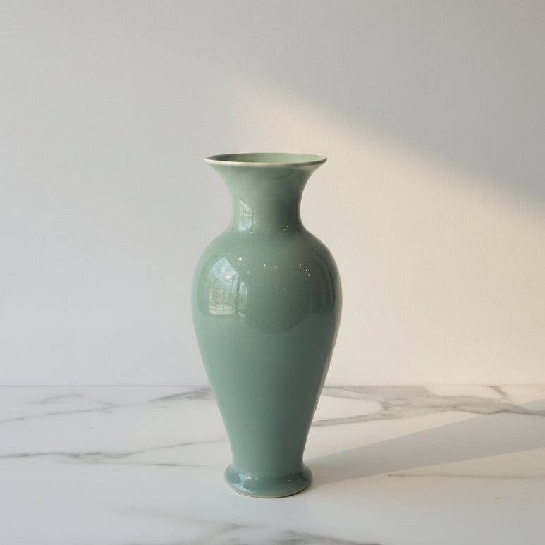 Green ceramic vase on counter with dried eucaplyptus