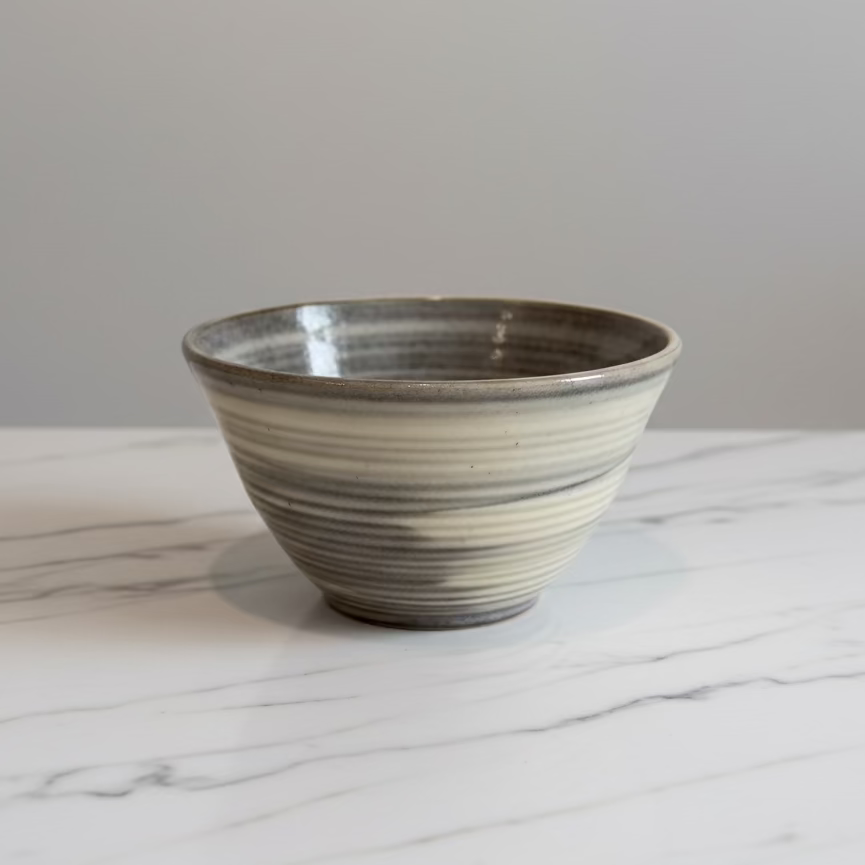 A handmade ceramic bowl with a rustic, hand-rolled texture and a glossy glaze.