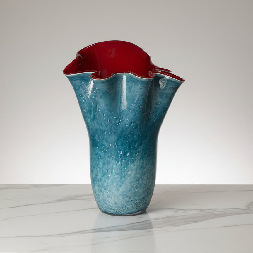 A blue and red blown glass vase with a speckled pattern.