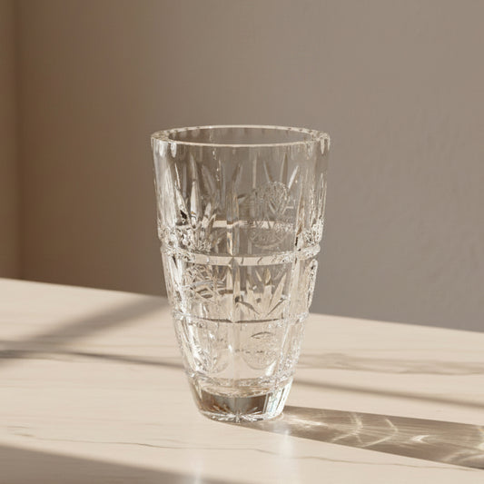 A clear cut-crystal style vase with a tapered conical shape