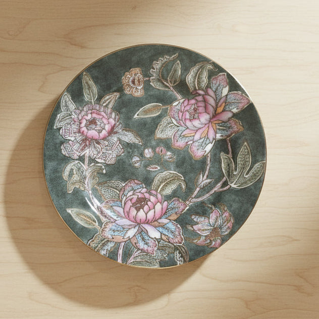 A round decorative table or tray with a dark gray background and a pink floral pattern.