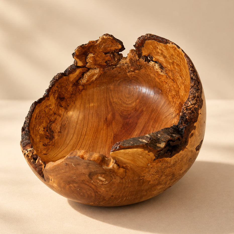 A rustic handcrafted wooden bowl with a rough, natural bark edge and visible wood grain.