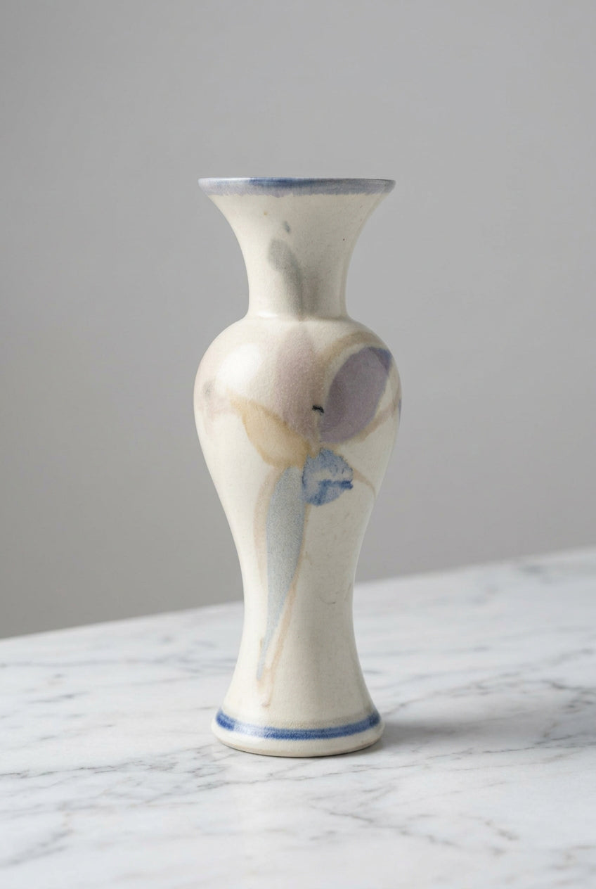 A small ceramic vase with a flared neck and bulbous body, painted in an abstract style with cream, blue, and gray tones.