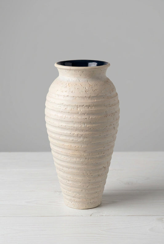 A tall, ribbed ceramic vase in a textured cream-beige finish with a glossy black interior.