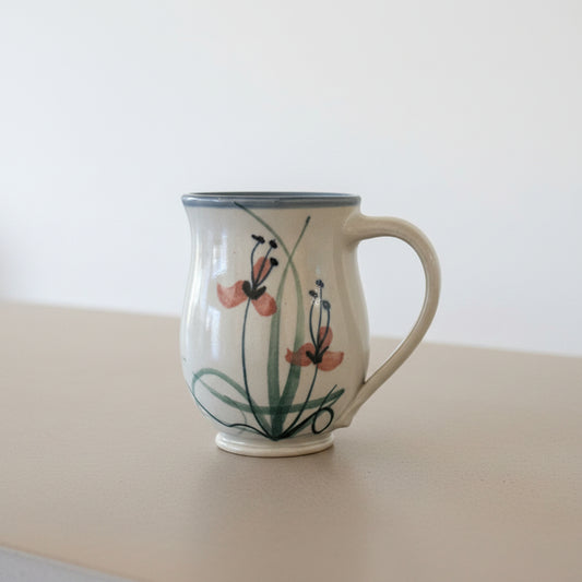 Ceramic mug with floral design on a wooden surface