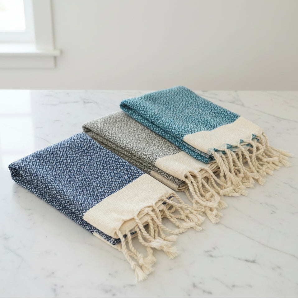 Three folded woven towels with tassels 