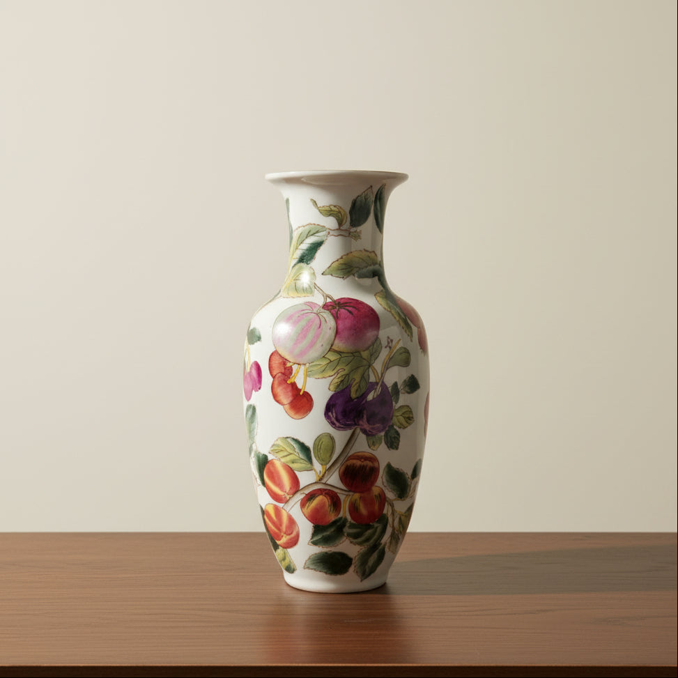 A white ceramic vase decorated with a colorful hand-painted fruit pattern.