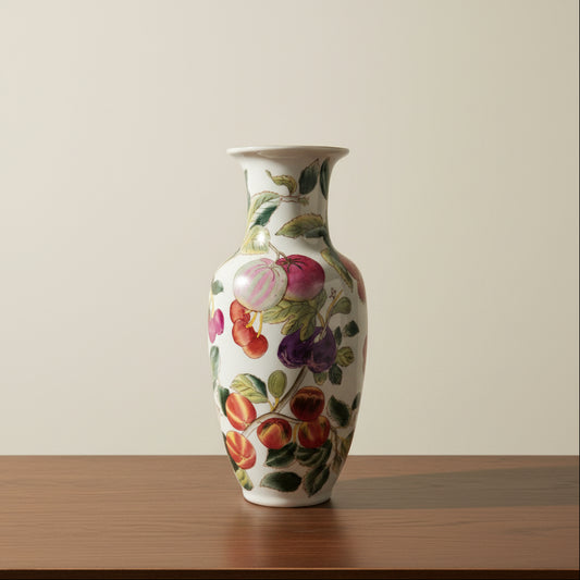 A white ceramic vase decorated with a colorful hand-painted fruit pattern.