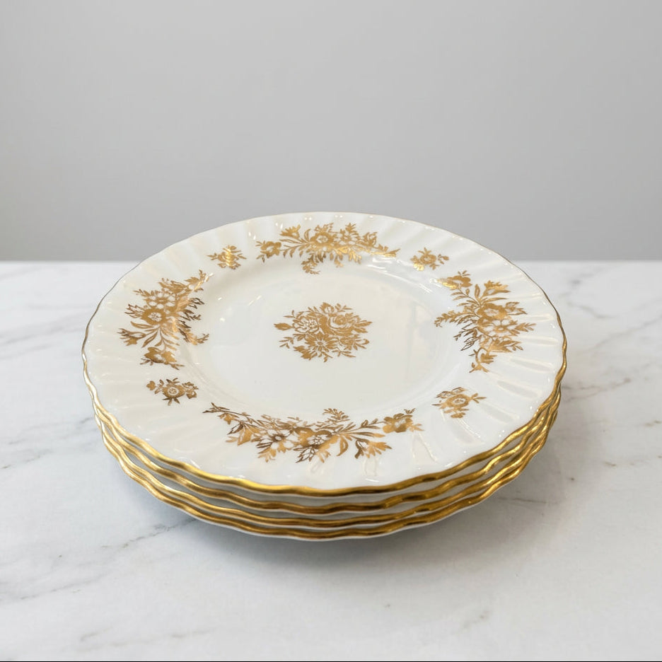 white porcelain plates with elegant gold floral patterns and gold-trimmed edges.
